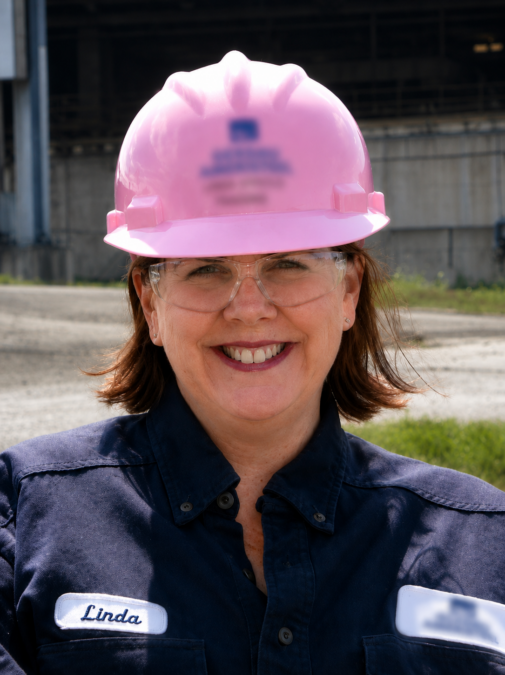 Linda in a hardhat and safety glasses on site